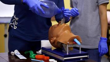 Training session of giving first aid. Person does the training reanimation procedure on a dummy with breathing system. video