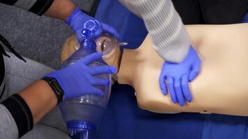 Medical training session. Practitioners doing a compression of heart attack on a dummy for first aid skills. video