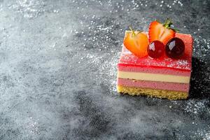 A piece of cake with strawberries and cherries on top photo
