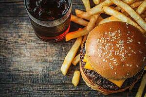 A hamburger and fries on a wooden table photo