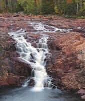 Long exposure of a waterfall Brattfallet on red rocks, in Varmland, Sweden. photo