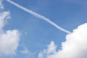 Cloudscape and contrail on blue sky. photo