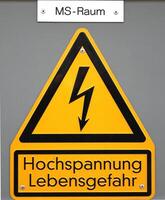High voltage sign in Germany. The top line means Mittelspannungs-Raum medium voltage area, the lower lines mean high voltage life danger. photo