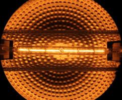 Halogen tube lamp with reflecting metallic background. photo