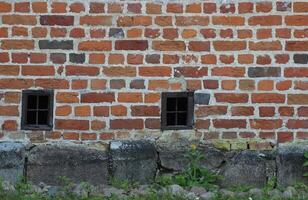 Wall with small windows at the basement of a church building near Greifswald, Mecklenburg-Vorpommern, Germany. photo