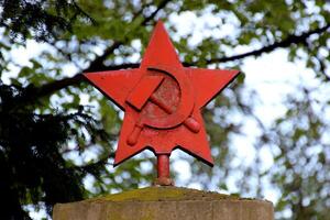 Red star with hammer and sickle, a memorial for the fallen russian soldiers in WWII, on a cemetary in Greifswald, Germany. photo