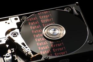 Hard disk on a black background, reflecting error message. photo