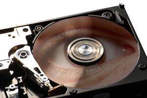 Hard disk on a black background, reflecting eye closeup. photo