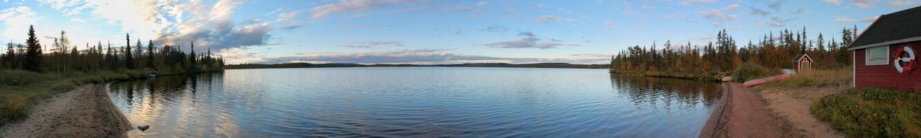 Panoramic view of a small beach with a small Swedish hut in Norrbotten, Sweden. photo