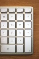 Numpad of an Apple keyboard on wooden desk. photo