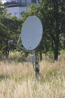 Satellite dish on a rod on the ground. photo