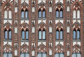 Facade of a historic city center building in the style of brick gothic with many windows. This architectural style was used from the 12th to the 16th century. photo