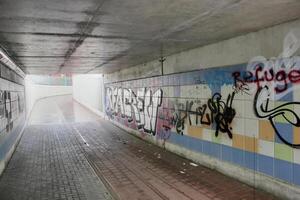 Undercrossing with graffiti and garbage under a railroad in Greifswald, Mecklenburg-Vorpommern, Germany Image was created using a HDR imaging technique photo