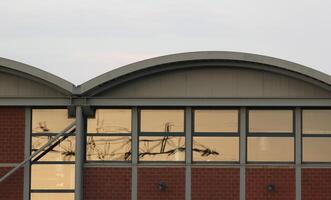 Windows with orange reflection of power line on an industrial building. photo