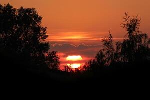 Sun going down on burning sky. photo