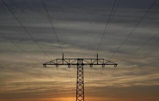 Symmetrical view on a high voltage power line during evening. The sky shows splendid colors. photo