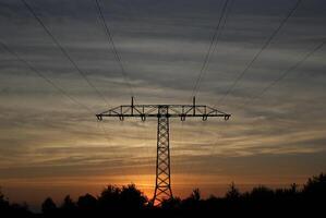 Symmetrical view on a high voltage power line in the evening. The sky shows splendid colors. photo