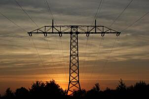 Symmetrical view on a high voltage power line in the evening The sky shows splendid colors photo