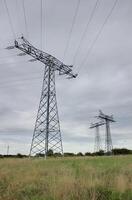 Three pillars of high voltage power lines in Mecklenburg-Vorpommern, Germany photo