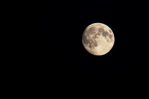 Nearly full moon, isolated on black. photo