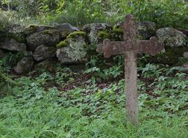 Old iron cross as tombstone besides a church ruin in Smaland, Sweden. photo