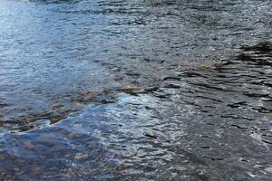 Reflections on a Swedish river with rocks photo