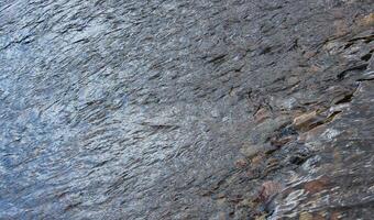 Reflections on a Swedish river with rocks. photo