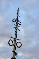 Traditional Swedish maypole in Dalarna. Dacing around a maypole is an activity that attracts many people celebrating midsummer. photo