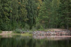 Edge of water with stones and a bridge in Sweden. photo