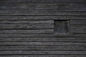 Dark wooden texture of log cabin with old window. photo