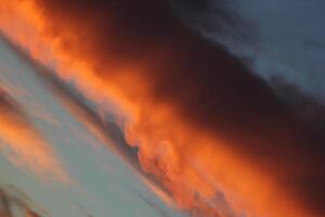 Burning orange cloud in sunset in unusual angle. photo