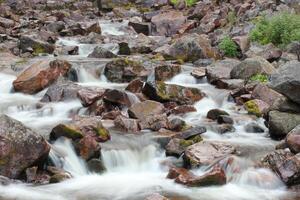 Rapids at the bottom of the Njupeskaer waterfall in the Fulufjaellet National Park in Dalarna, Sweden. The image was shot with long exposure resulting in smooth water. photo