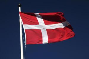 Flag of Denmark on dark blue sky photo
