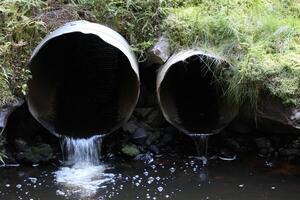 Small and big water pipe in a stream. photo
