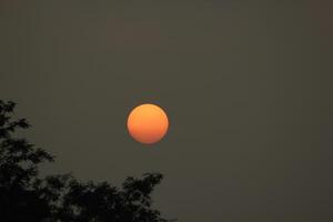 Deep orange sun in polluted sky photo
