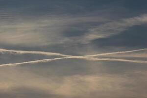 Evening cloudscape with crossing contrails. photo