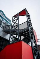 A vibrant red and black staircase leads to a contemporary building that merges innovative engineering with stunning design, showcasing a perfect balance of materials and aesthetics photo