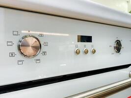 A detailed closeup view of a pristine white oven that features a clock prominently displayed on its surface, showcasing its timekeeping functionality as a home appliance photo