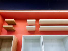 The stores organized shelves against a vibrant red wall enhance their appearance, showcasing diverse products that create an inviting shopping environment for customer exploration photo