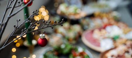 A beautifully decorated Christmas tree with sparkling ornaments sits atop a table full of delicious pizzas, creating a joyous festive atmosphere for everyone to enjoy together photo