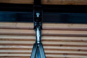 This is a detailed closeup view of a shiny metal object that is suspended from the ceiling inside a rustic wooden structure, showcasing the unique blend of materials and design elements photo
