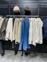 In a beautifully designed and stylish retail store, a modern rack elegantly showcases a wide and diverse array of chic outfits, which are ideal for various events and special occasions photo