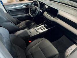 A modern vehicle showcases its elegant design with stylish black seating and an ergonomic steering wheel, cultivating a warm and inviting atmosphere for both drivers and passengers alike photo