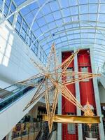 A large, beautiful star is suspended gracefully from the ceiling of a magnificent building, creating a stunning visual element that captivates everyone who walks underneath it photo