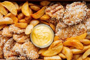 Here we have a closeup view of a delicious and appealing plate of food featuring crispy french fries alongside golden chicken nuggets, creating a lovely fast food feast for anyone to enjoy photo