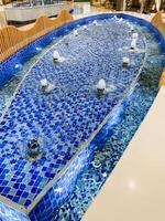 There is a unique fountain located within the shopping mall that remarkably resembles a coffin, making it a striking piece of art that draws attention from all who visit photo