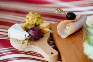 An exquisite artisanal platter featuring a delightful assortment of premium cheeses, fresh grapes, and an array of savory delights for an exceptional dining experience photo