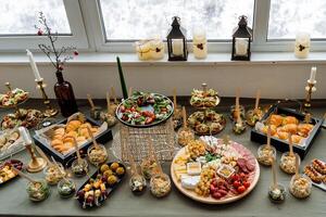 On the table, there is a vast assortment of various types of delicious food that is presented in a way that everyone seated there can enjoy and savor every bite together photo