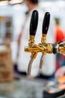 This image shows a closeup of a beautifully designed beer tap with two unique handles, showcasing exceptional craftsmanship and inviting enthusiasts to enjoy a refreshing drink together photo