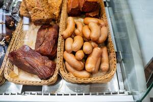 A beautifully arranged display case filled with an enticing variety of meats, including different types of sausages, showcasing the culinary delights available to customers photo